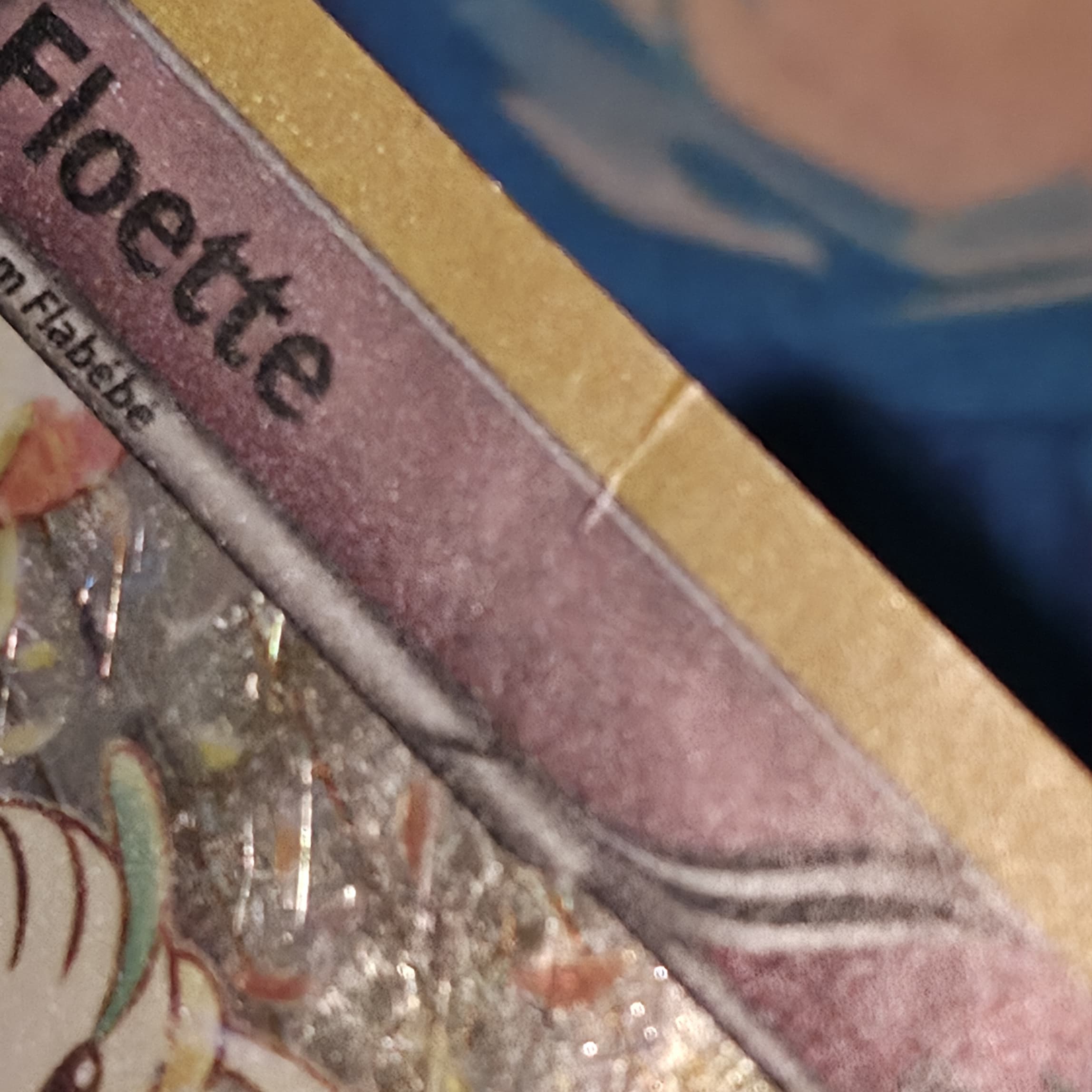 Floette Pokemon card before crease repair — visible crease line across the border and surface