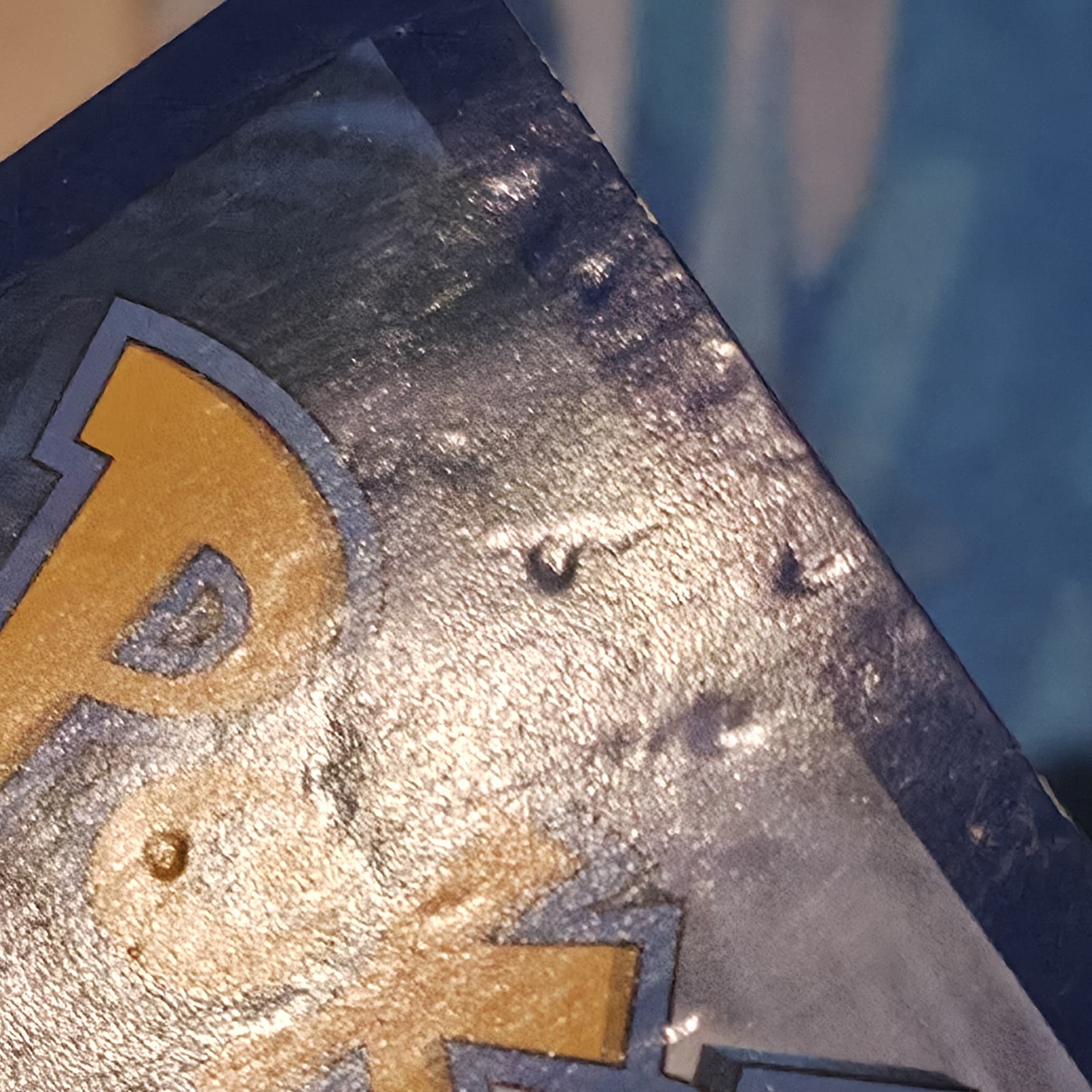 Gengar Pokemon card back before deep dent repair — crater-like dents on the blue border