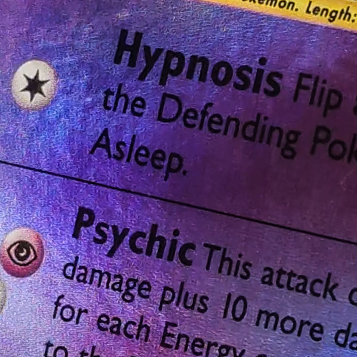 Mewtwo Pokemon card after scratch repair — attack text and surface look cleaner