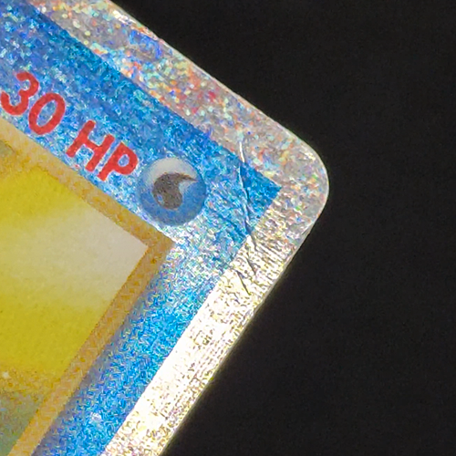 Tentacool Pokemon card before crease repair — crease through the HP energy symbol